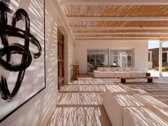 Intérieur d'une villa de luxe à Antipaxos avec des canapés blancs et une œuvre d'art moderne.
