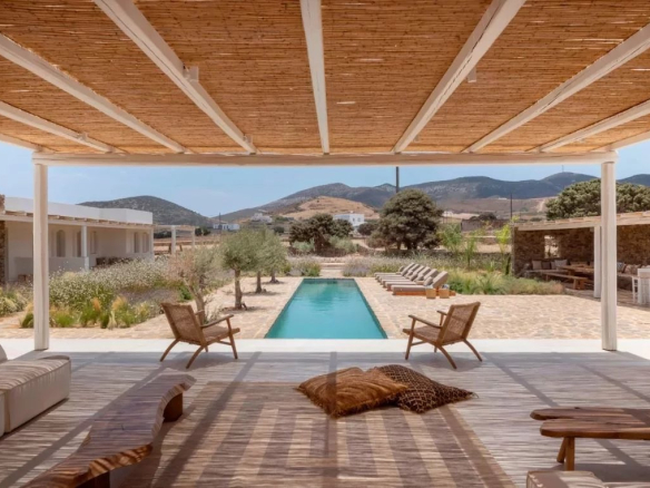Vue d'une villa de luxe à Antipaxos avec piscine et chaises longues dans un cadre paisible.