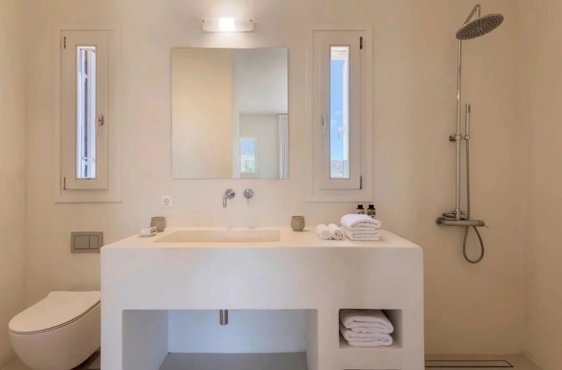 Salle de bain de villa de luxe à Antipaxos Salle de bain moderne avec lavabo, miroir et douche dans une villa de luxe à Antipaxos, Grèce.
