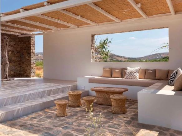 Espace extérieur d'une villa de luxe à Antiparos, Grèce, avec des sièges confortables et une vue dégagée.