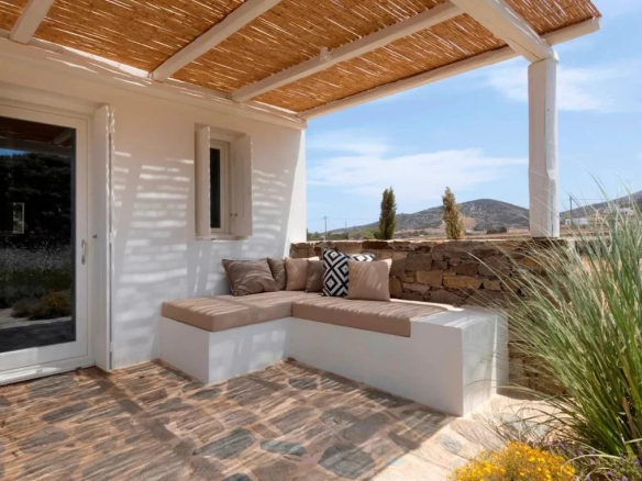 Terrasse d'une villa de luxe à Antipaxos, Grèce, avec un coin salon confortable et vue sur la nature.