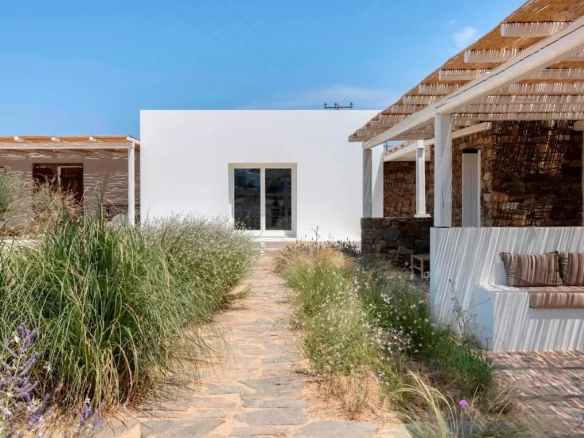 Allée menant à une villa moderne entourée de verdure à Antipaxos, Grèce.