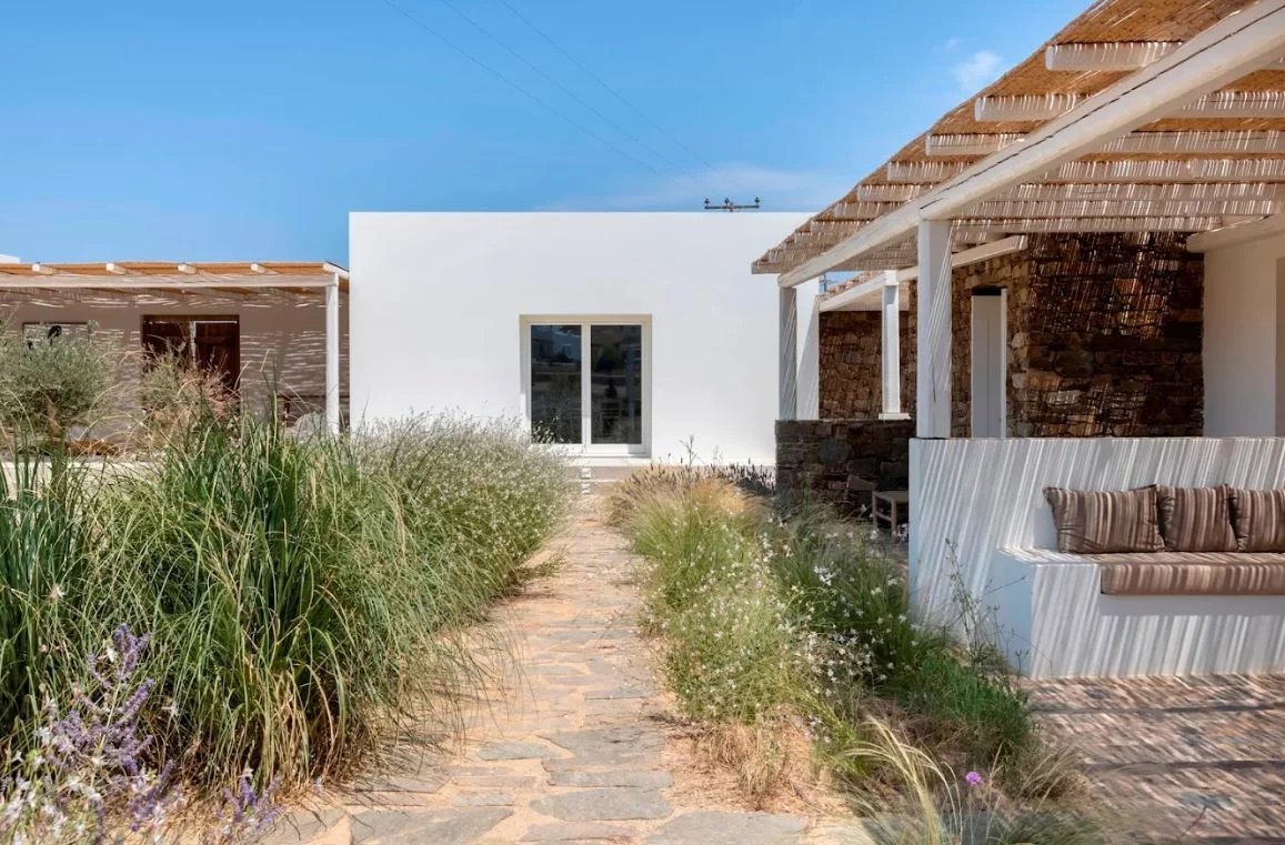 Villa de luxe à Antipaxos Allée menant à une villa moderne entourée de verdure à Antipaxos, Grèce.