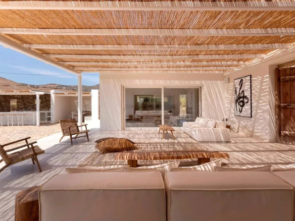 Terrasse d'une villa de luxe à Antipaxos, Grèce, avec des chaises et un espace de détente.