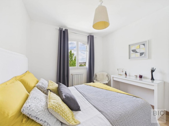 Chambre d'une maison familiale spacieuse avec lit et décoration moderne.