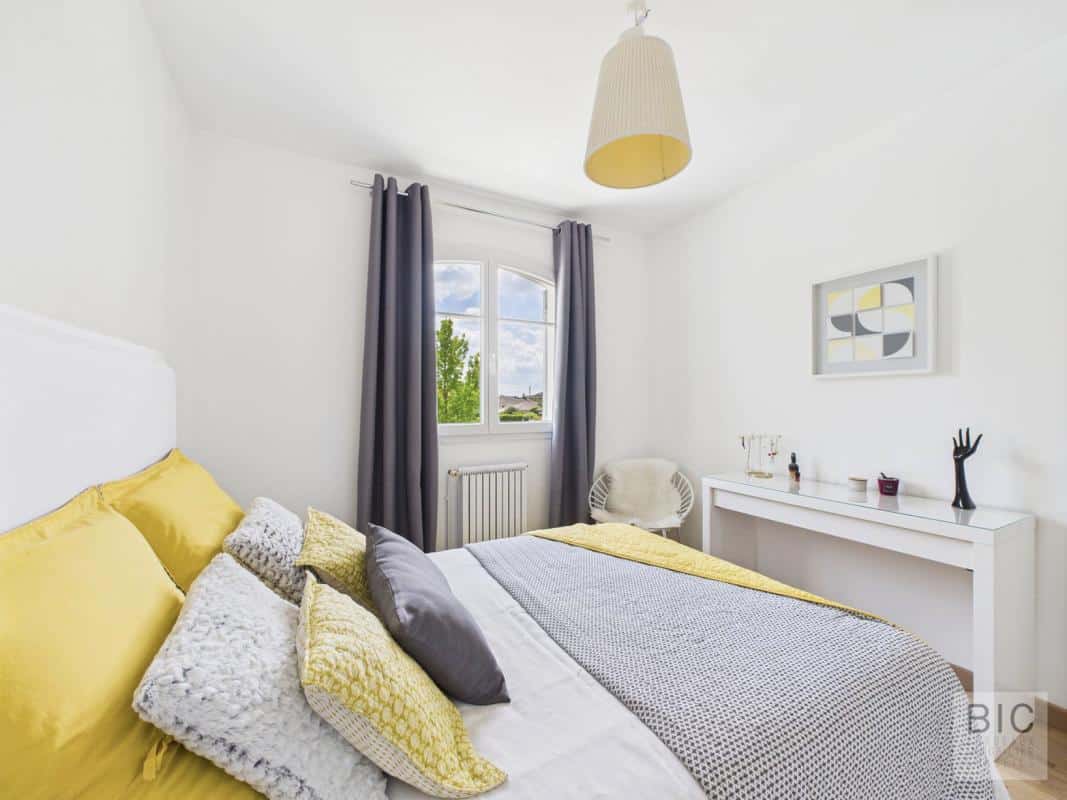 Chambre d'une maison familiale spacieuse avec lit et décoration moderne.