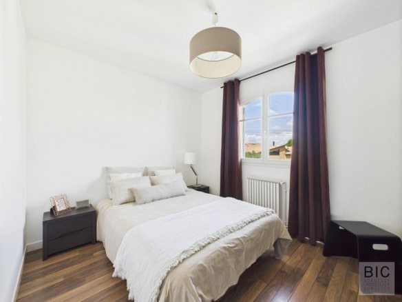 Chambre d'une maison familiale à Mérignac avec lit et décoration moderne.