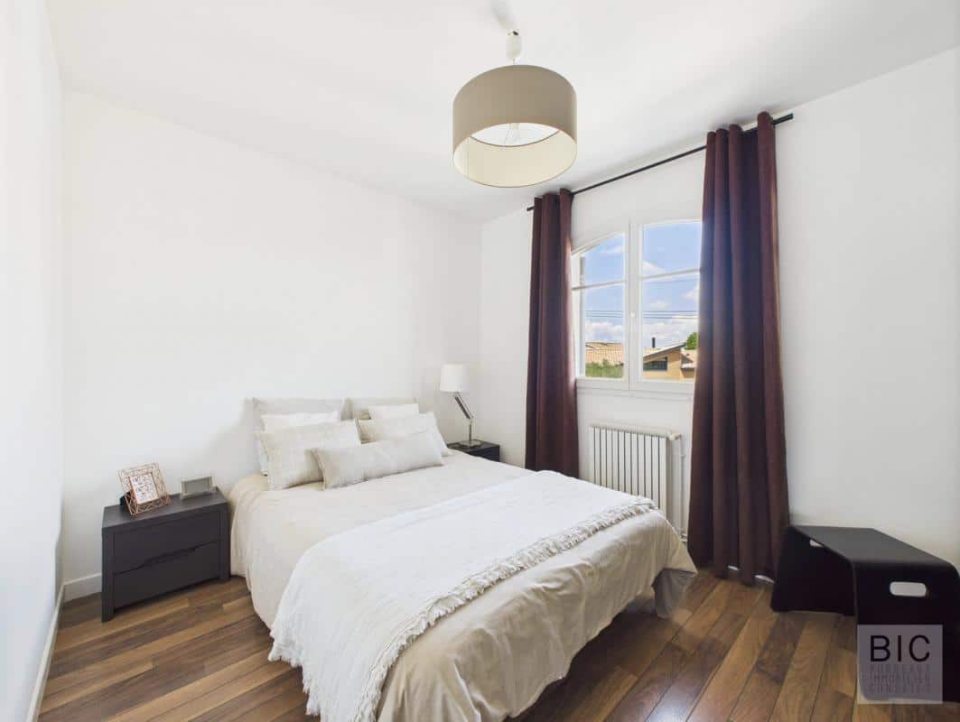Chambre d'une maison familiale à Mérignac avec lit et décoration moderne.