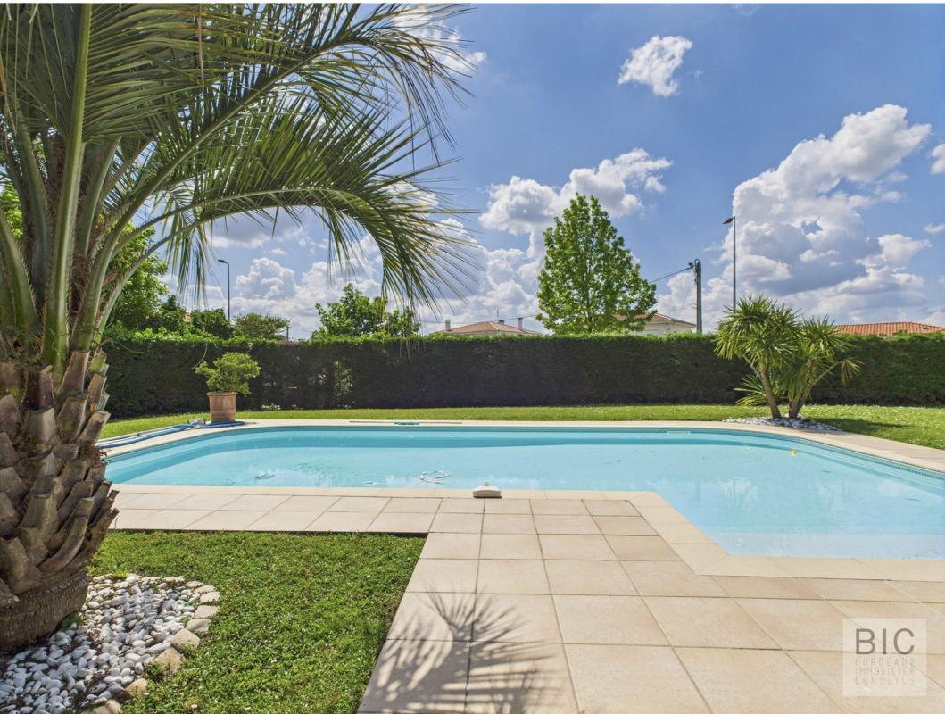Piscine entourée de verdure dans un jardin bien entretenu