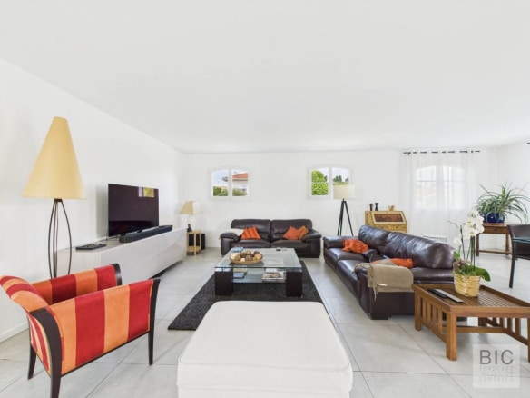 Intérieur d'une maison familiale spacieuse avec salon lumineux et mobilier moderne.