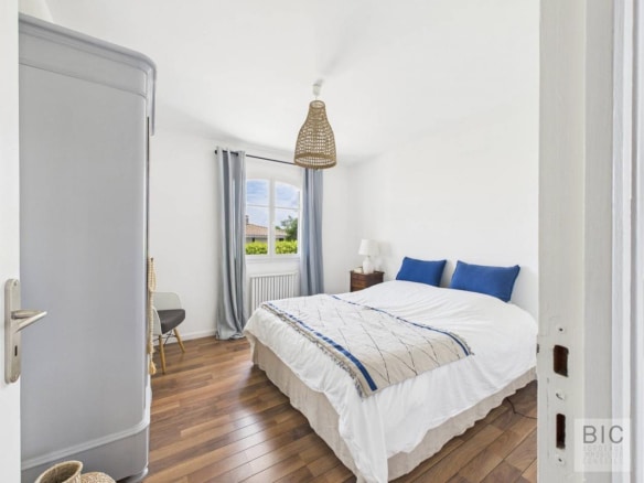 Chambre d'une maison familiale spacieuse à Mérignac, avec lit double et décoration lumineuse.
