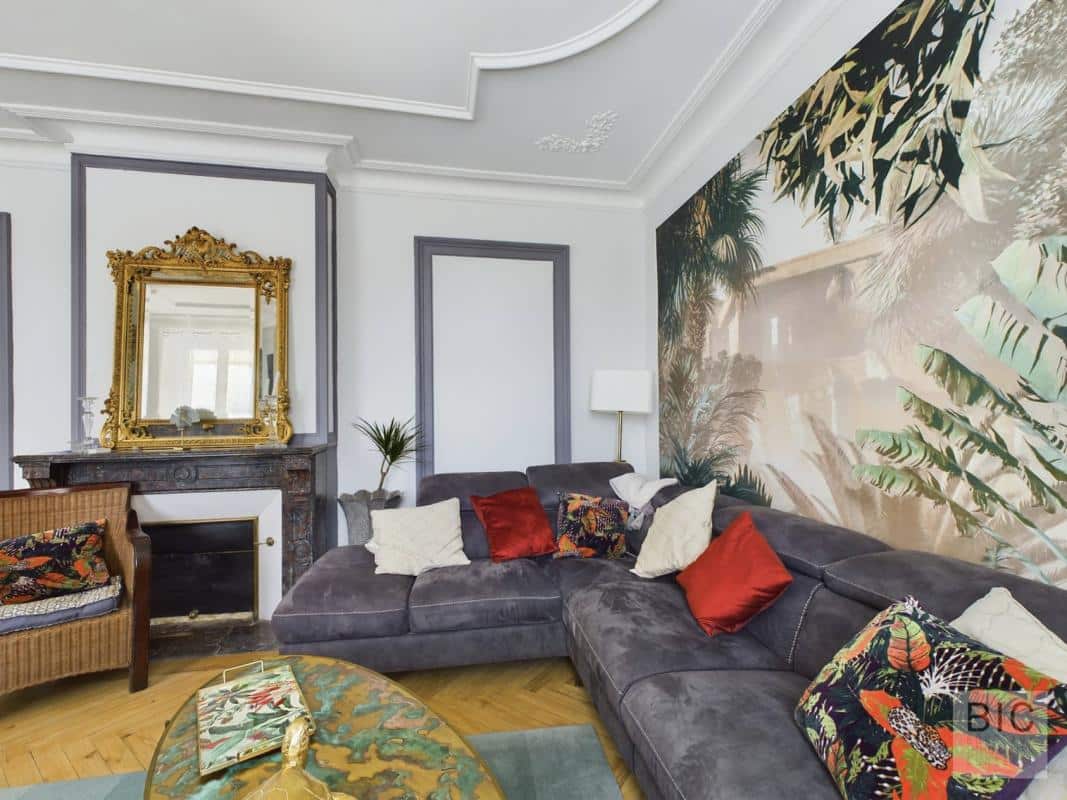 Salon d’une maison coloniale Salon d'une maison coloniale avec canapé gris et décoration tropicale à Villenave-d'Ornon.