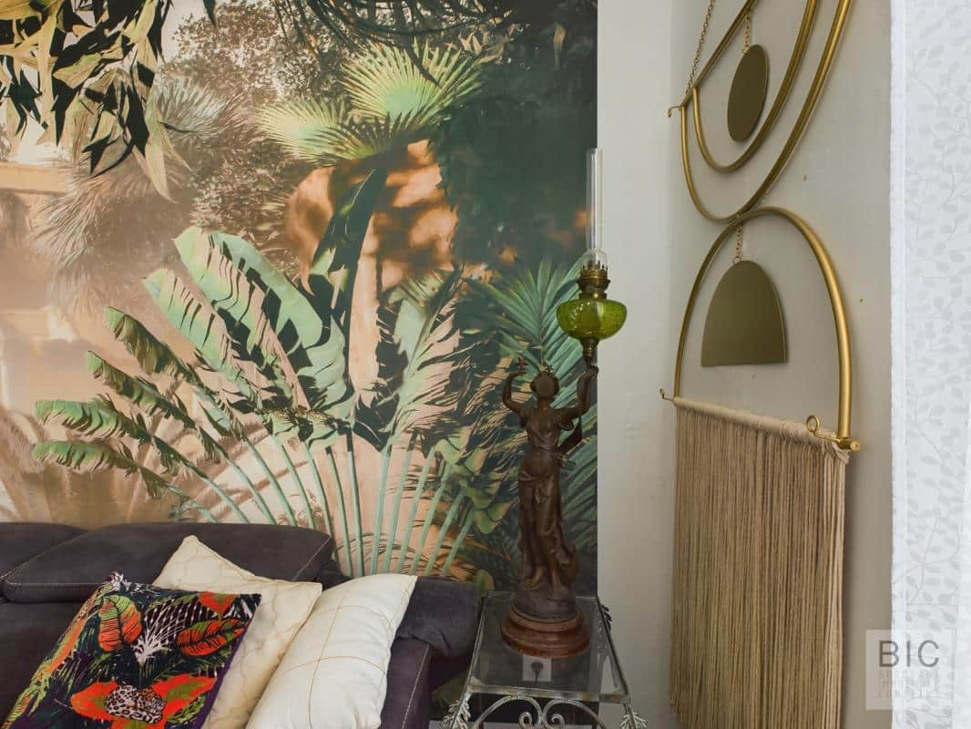 Détail de décoration intérieure Détail d'un salon avec une décoration tropicale, incluant des plantes et des éléments en or.