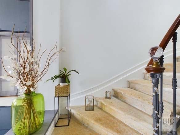 Escalier en pierre avec décoration florale dans une maison coloniale.