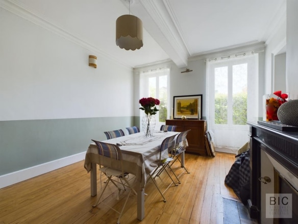 Salle à manger d'une maison coloniale avec table et chaises, lumière naturelle