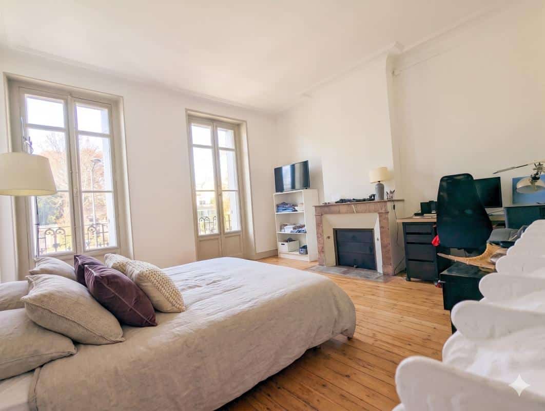Chambre d’une maison en pierre à Bordeaux Chambre lumineuse avec lit, bureau et fenêtres à Bordeaux.