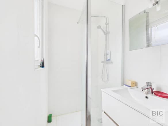 Salle de bain moderne avec douche et lavabo dans une maison en pierre à Bordeaux.