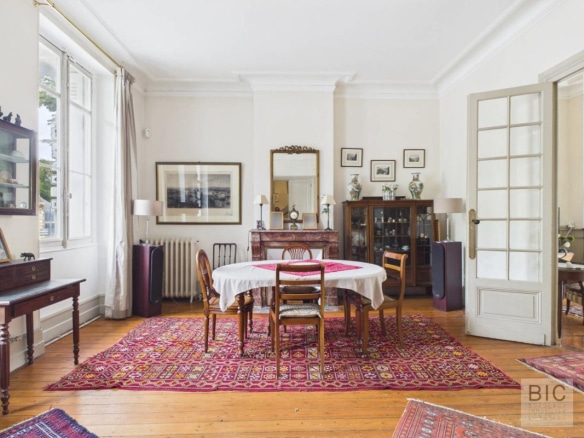 Intérieur d'une maison en pierre avec salle à manger, tapis et meubles anciens à Bordeaux.