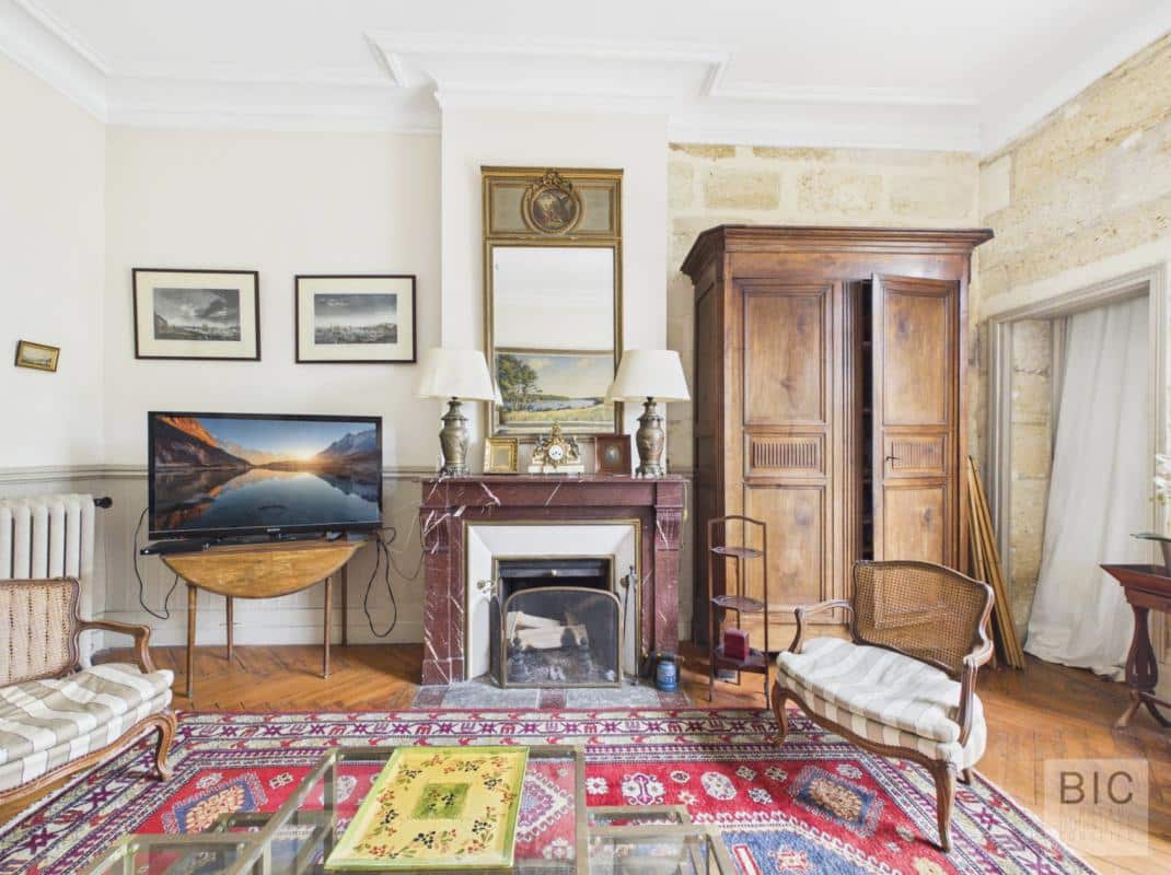 Intérieur d’une maison en pierre à Bordeaux Intérieur d'une maison en pierre avec salon, cheminée et télévision à Bordeaux.