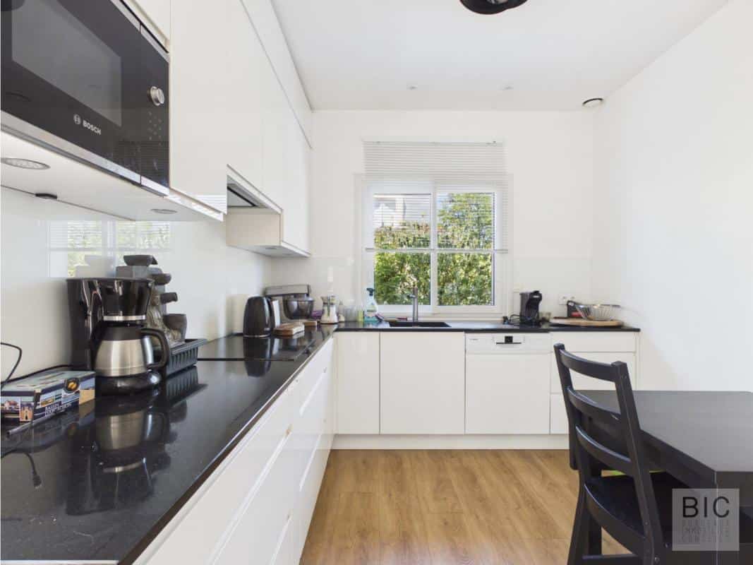 Cuisine moderne à Bordeaux Cuisine moderne avec meubles blancs et plan de travail noir, lumière naturelle à Bordeaux.