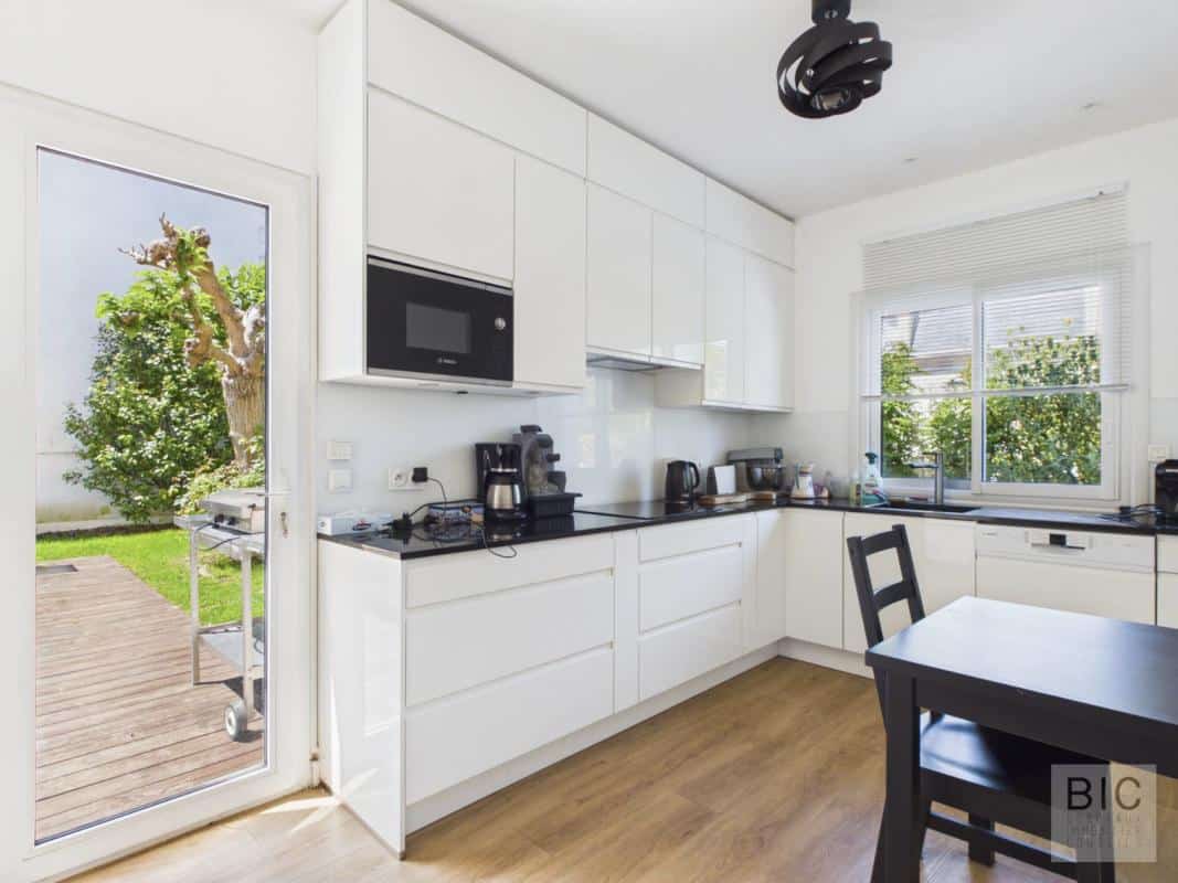 Cuisine d’une maison à Bordeaux Cuisine moderne et lumineuse d'une maison à Bordeaux, avec accès à un jardin.