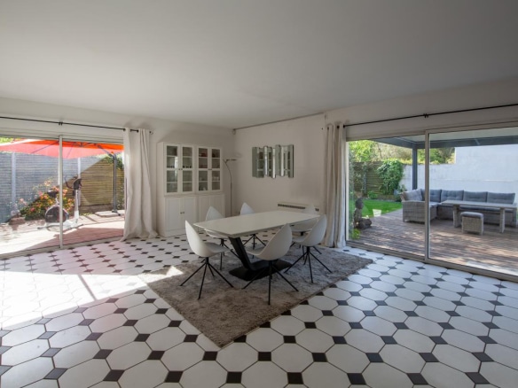 Intérieur d'une maison à vendre à Bordeaux, avec salle à manger et accès au jardin.