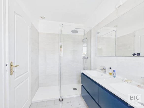 Salle de bain moderne avec douche à l'italienne et double vasque.