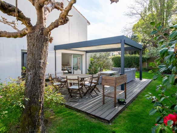 Terrasse en bois avec mobilier de jardin dans un jardin verdoyant, maison à Bordeaux Caudéran.