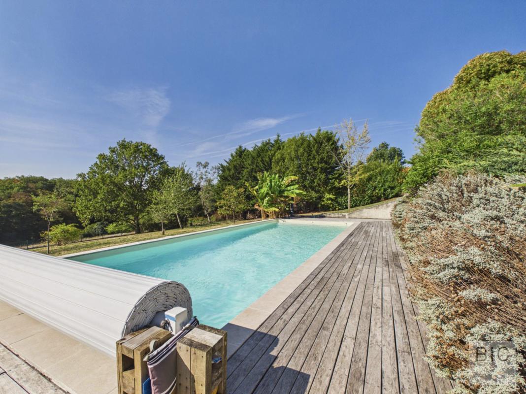 Piscine dans un parc à Pompignac Piscine entourée de verdure dans un parc arboré à Pompignac