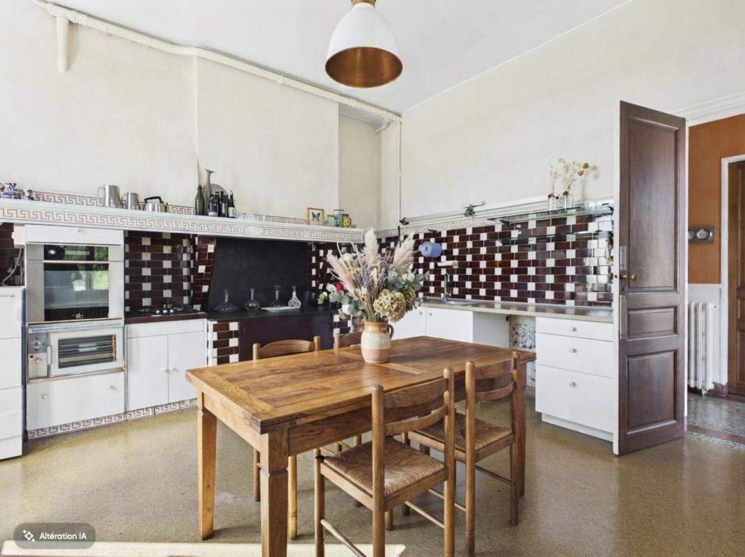 Cuisine d’une maison de maître à Pompignac Cuisine d'une maison de maître avec table en bois et carrelage en damier.