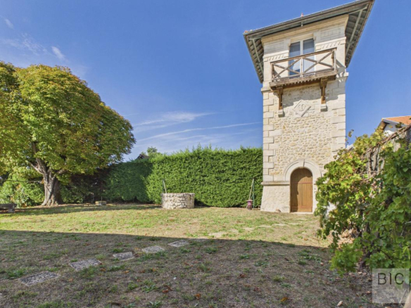 Tour en pierre d'une maison de maître avec jardin arboré à Pompignac.