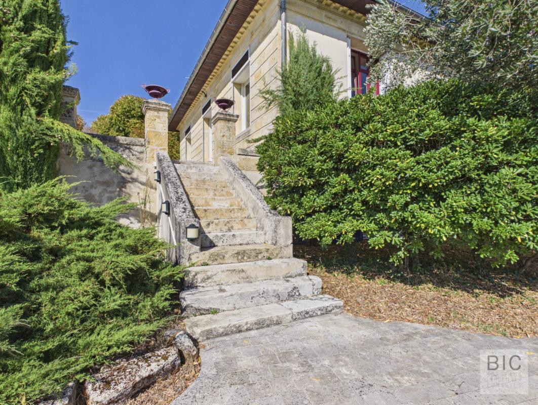 Maison de maître à Pompignac Escalier menant à une maison de maître en pierre avec jardin verdoyant à Pompignac.