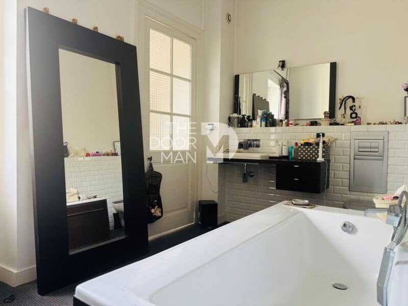 Bathroom with bathtub and mirror, decorated in a modern style.