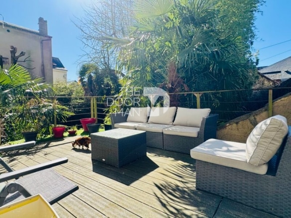 Wooden terrace with garden furniture and plants, house in town in Laval.
