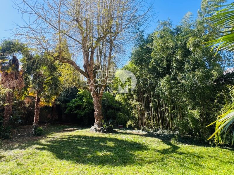 Garden of a house in Laval with trees and greenery