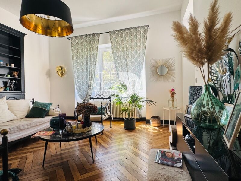 Interior of a townhouse in Laval with a bright living room, plants and wooden parquet flooring.