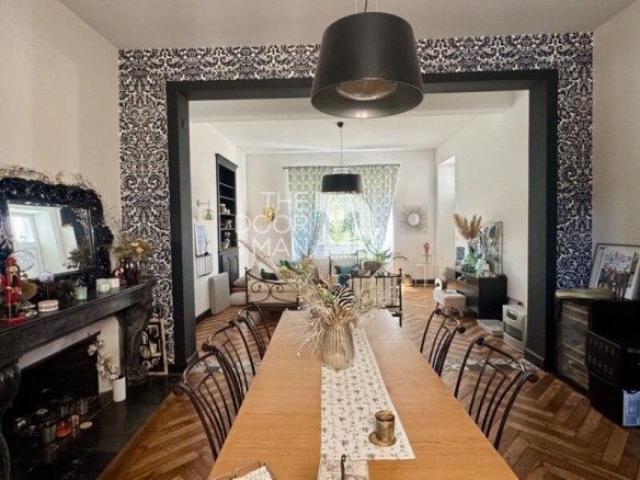 Interior of a townhouse in Laval with a large table, a living room and decorative elements.