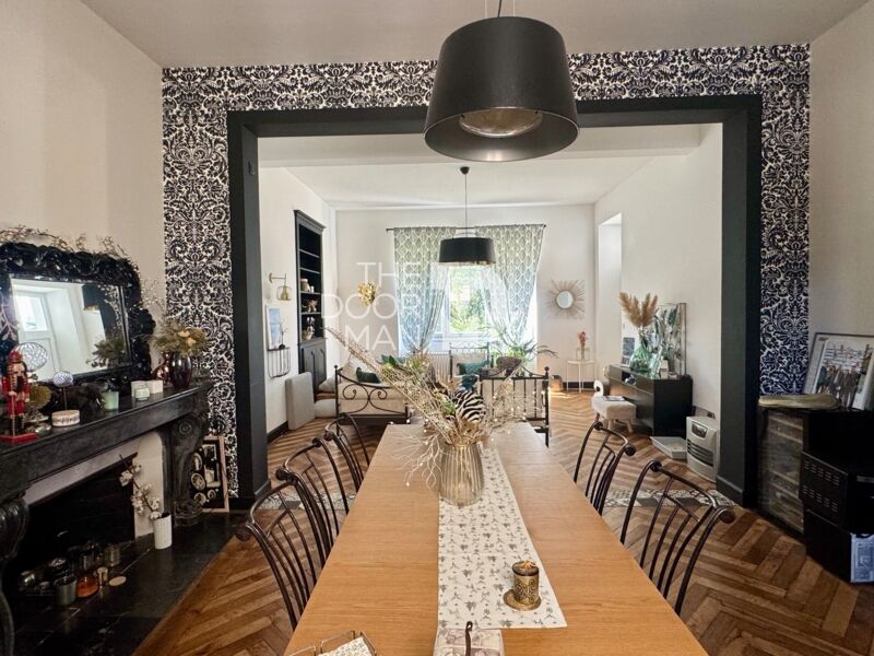 Interior of a townhouse in Laval with a large table, a living room and decorative elements.