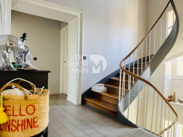 Interior of a townhouse in Laval with a wooden staircase and light-colored walls.