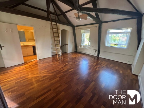 Intérieur d'une maison bourgeoise à Montfort-l'Amaury avec parquet et poutres apparentes.