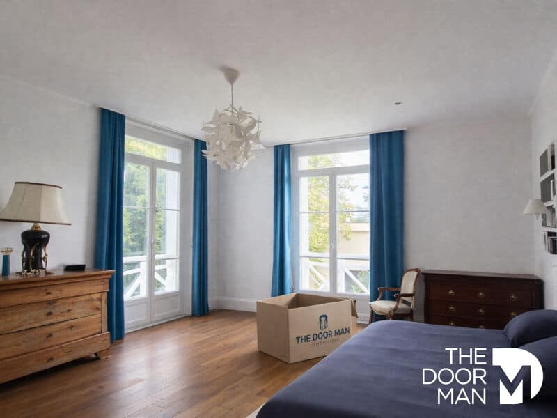 Chambre à Rambouillet Chambre spacieuse avec fenêtres, parquet et mobilier en bois, éclairage naturel.
