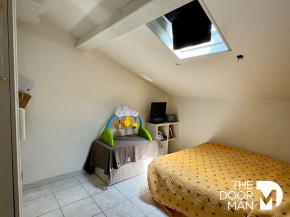 Attic bedroom with double bed and child's bed, skylight