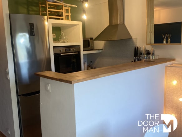 Cuisine moderne ouverte avec bar et appareils électroménagers dans une maison à Grimaud.