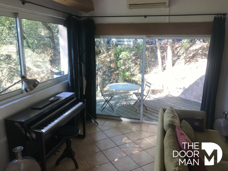Intérieur d'une maison à Grimaud avec un piano et une terrasse ensoleillée.