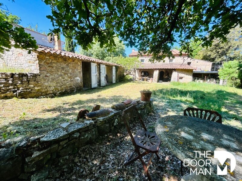 Propriété historique à Flassans-sur-Issole Vue d'un jardin avec une table en pierre et des bâtiments en pierre au cœur d'une propriété à Flassans-sur-Issole.