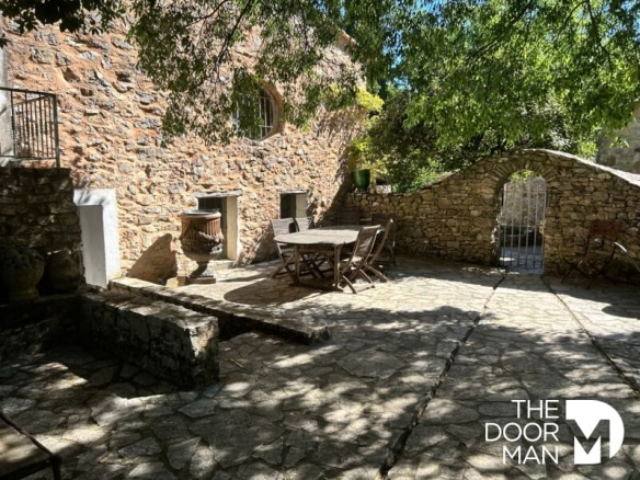 Terrasse en pierre d'une propriété en rénovation, entourée de verdure à Flassans-sur-Issole.
