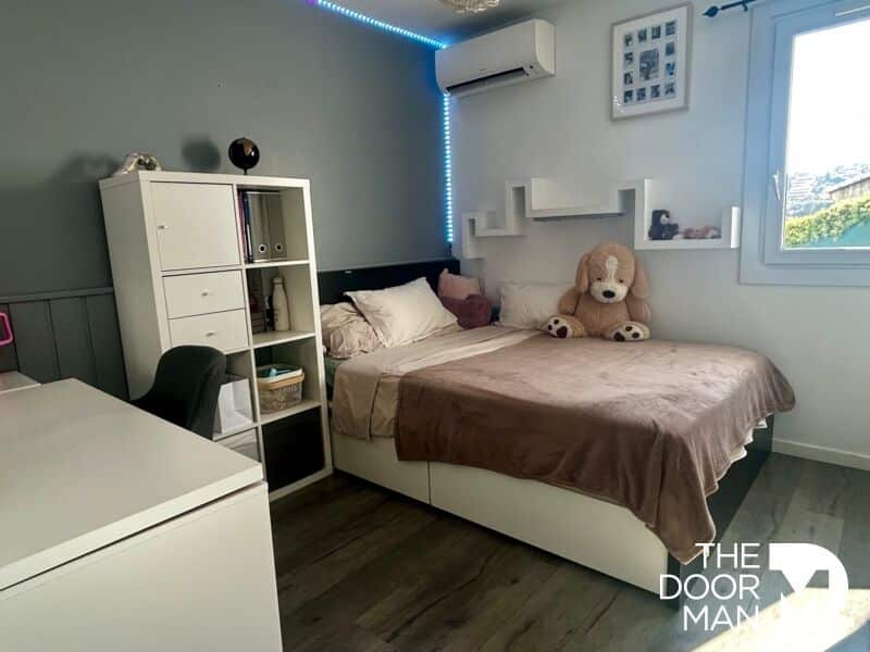 Room in a house in Le Lavandou Bedroom in a house with bed, desk and shelves, decorated with neutral colors.
