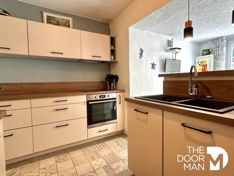 Home cooking in Le Lavandou Modern kitchen in a house in Le Lavandou with wooden elements and integrated appliances.