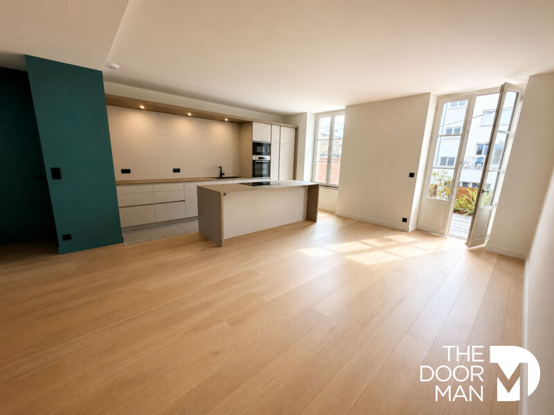 Appartement T4 à Dinard Intérieur d'un appartement T4 moderne à Dinard avec cuisine ouverte et lumière naturelle.