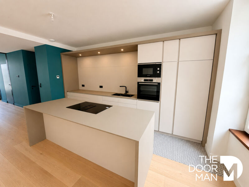 Cuisine d’un appartement T4 à Dinard Cuisine moderne d'un appartement T4 à Dinard, avec îlot central et équipements haut de gamme.
